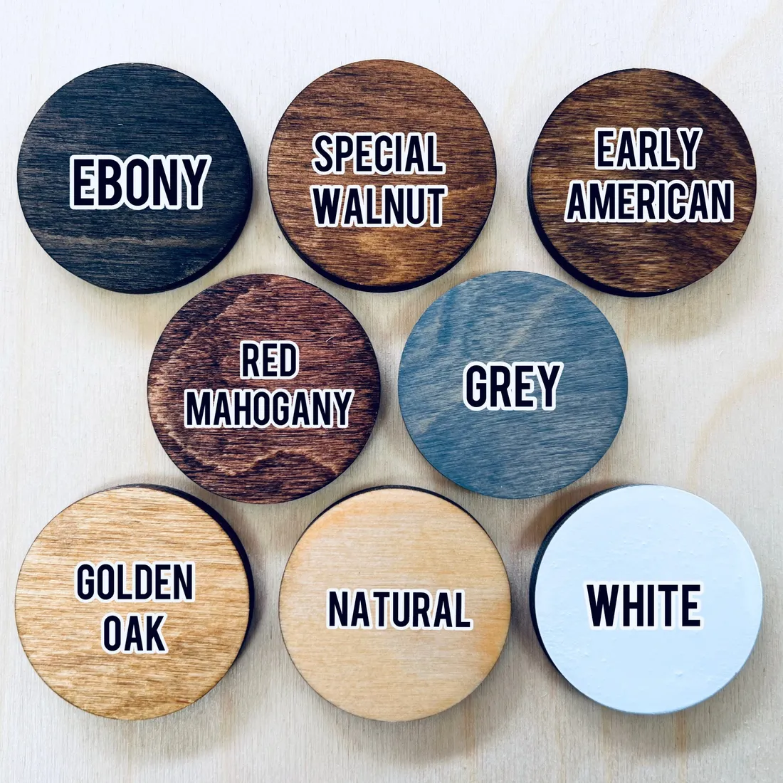 Eight stained wood discs labelled Ebony, Special Walnut, Early American, Red Mahogany, Grey, Golden Oak, Natural and White.