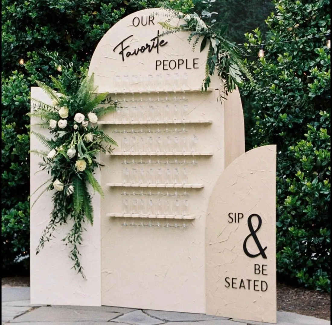 Arched wedding seating chart reading Favorite People beside a floral arrangement.