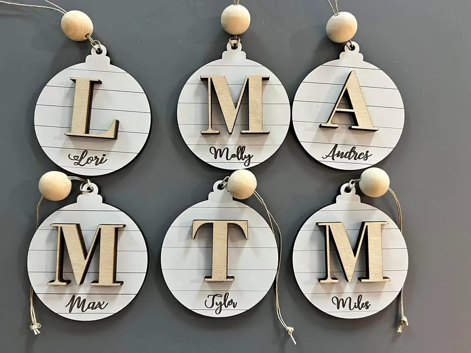 Shiplap-style wooden ball ornaments with raised initials and engraved names.